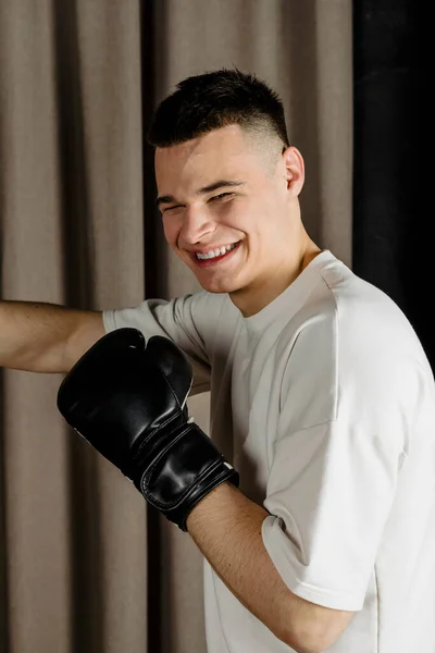 Боксер Тренируется Боксерской Грушей Уютной Бежевой Студии Наносит Удар — стоковое фото