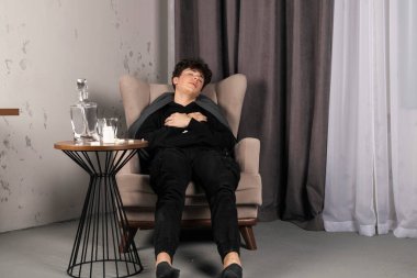 Depresyonda olan bir adam yanında ilaç ve haplarla dolu bir masada uyuyakaldı. Zihinsel sorunları olan genç bir adam..