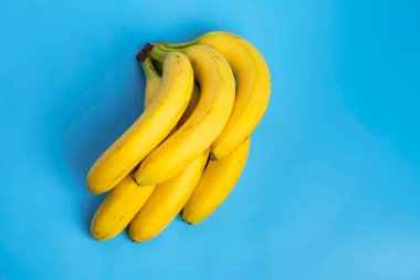 Mavi arka planda izole edilmiş bir grup muz. en üstteki görünüm.