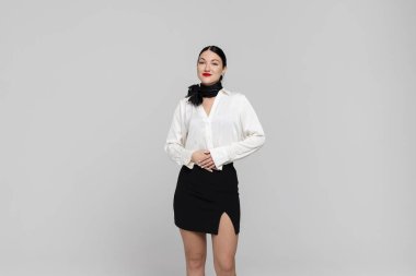 Çekici genç bir hostesin portresi. Çekici, güler yüzlü, seksi üniformalı hostes. Beyaz arka planda izole edilmiş. Stüdyo çekimi.