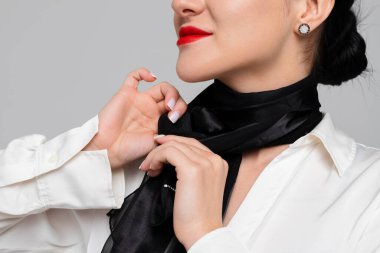 Çekici genç hostes atkısını sıkıyor. Şehvetli üniformalı, gülümseyen bir hostes. Beyaz arkaplanda izole.