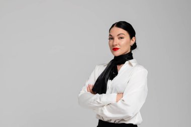 Çekici genç bir hostesin portresi. Çekici, güler yüzlü, seksi üniformalı hostes. Beyaz arka planda izole edilmiş. Stüdyo çekimi.