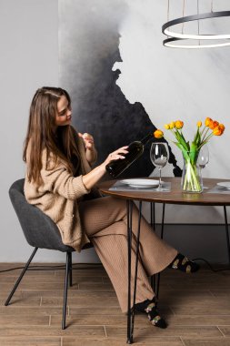 Güzel esmer kadın kendine şarap dolduruyor.