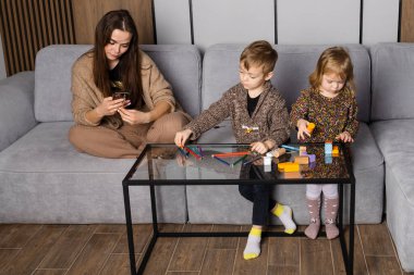 Anne ya da dadı çocuklara dikkat etmez, onları görmezden gelir ve telefonunu kullanır. Kardeşler oyun oynarken ve birlikte vakit geçirirken, oturma odasında çizim yaparken..