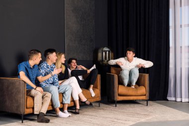 Beş arkadaş birlikte vakit geçiriyorlar, sessiz sinema oynuyorlar. Oturma odasında küçük bir arkadaş grubu. Eğlenceli sessiz sinema oyunu.