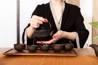 Kimonolu çekici beyaz kız ve saç çubukları Japon tarzında çay içiyor. Japon çay töreni.