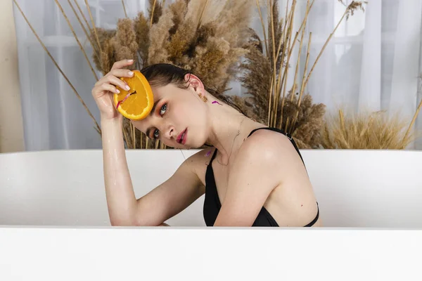 Affascinante Ragazza Seduta Bagno Posa Con Petali Fiori Fette Arancia — Foto Stock