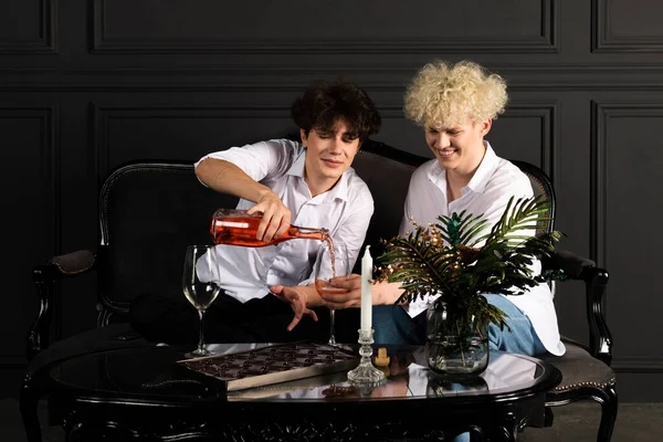シャンパンでお祝いする2人の若い男 ゲイのカップルのロマンチックな夜 ブロンドとブルネットが楽しく — ストック写真