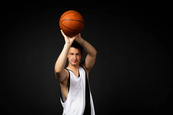 Stilig Ung Basketspelare Vita Sportkläder Kastar Boll Isolerad Svart Bakgrund — Stockfoto