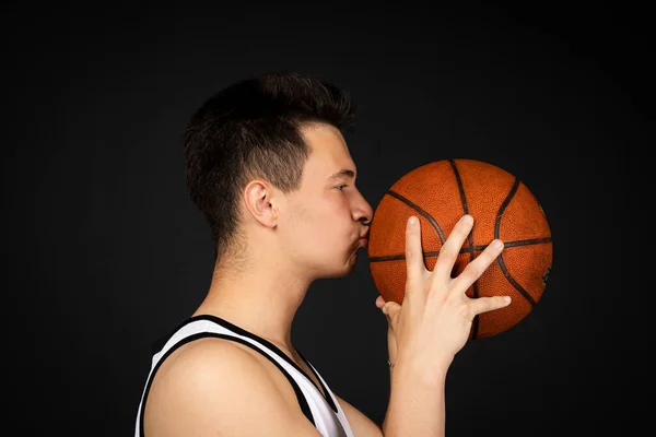 Stilig Ung Basketspelare Vita Sportkläder Kysser Boll Isolerad Svart Bakgrund — Stockfoto