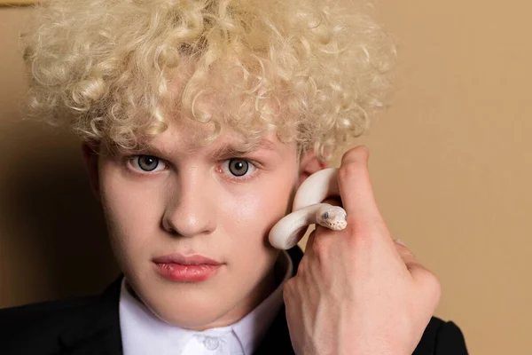 スタイリッシュなブロンドの髪の若い男とLeucistic Ball Python サラリーマンの手にある純白の蛇 — ストック写真