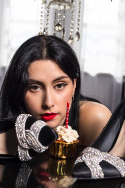 18. yaş gününü kutlayan siyah saçlı ve elbiseli zarif giyimli genç bir kız portresi. Resmi parti toplantısı. Yeni pahalı ayakkabı hediyesi.