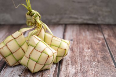 Pişmemiş ketupat pirinçle dolu, ahşap yüzeye yerleştirilmiş. Kurban gelenekleri, Asya mutfağı ya da kültür mirası hakkında makaleler, bloglar ya da internet kullanımı için mükemmel