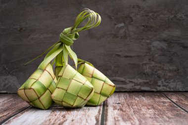 Pişmemiş ketupat pirinçle dolu, ahşap yüzeye yerleştirilmiş. Kurban gelenekleri, Asya mutfağı ya da kültür mirası hakkında makaleler, bloglar ya da internet kullanımı için mükemmel