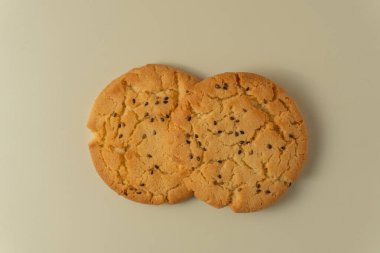 Susamlı kurabiye düzgünce dizilmiş, altın kabuğu ve serpiştirilmiş susam tohumları, atıştırmalık veya tatlı için ideal