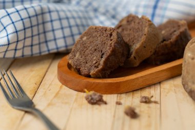 Muzlu çikolatalı pasta dilimleri düzgün sıralanmış, nemli dokuyu ve yumuşak ışıklandırmada zengin lezzeti gösteriyor.