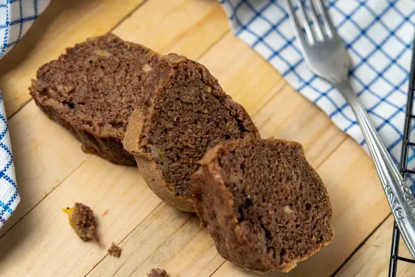 Muzlu çikolatalı pasta dilimleri düzgün sıralanmış, nemli dokuyu ve yumuşak ışıklandırmada zengin lezzeti gösteriyor.