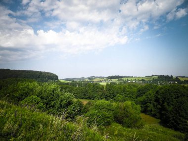 Tepeler, tarlalar ve çayırlar. Wiezyca 'nın güzel manzarası, Kashubia Bölgesi, Kuzey Polonya. Boşluğu mavi gökyüzünde kopyala.