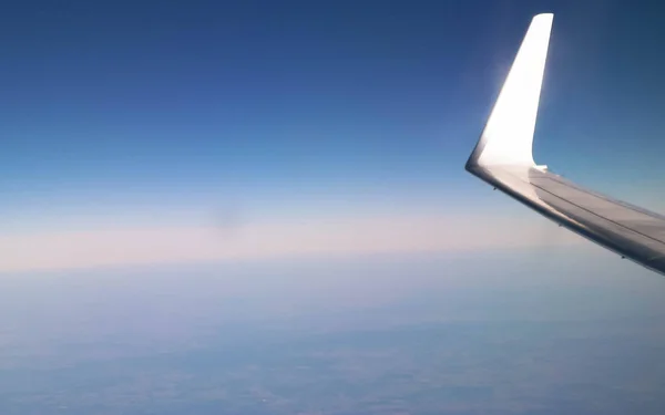 惑星地球と飛行機の翼の飛行機の窓からの眺め 交通機関の概念 — ストック写真