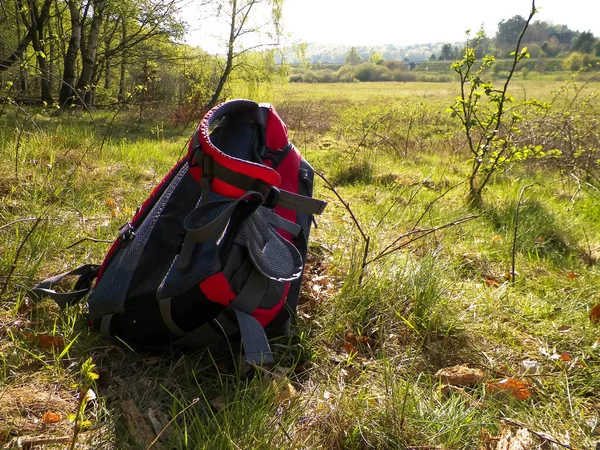 stock image Travel and excursions - backpack left in the field. Travel and exploration concept.