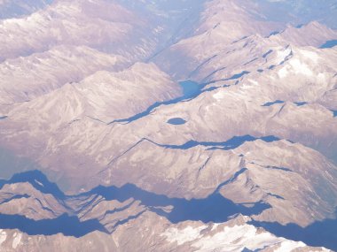 Alpler, uçağın penceresinden dağların manzarası. Toprak bükme ve doğa kavramı.