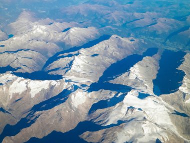 Alpler, uçağın penceresinden dağların manzarası. Toprak bükme ve doğa kavramı.