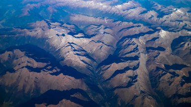 Alpler, uçağın penceresinden dağların manzarası. Toprak bükme ve doğa kavramı.