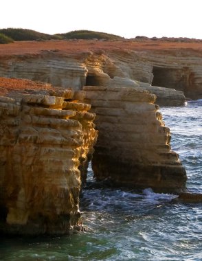 Kıbrıs adasının Paphos bölgesindeki Mercan Koyu 'na yakın kaya oluşumları ve su mağaraları. Popüler bir turistik site. Yaz mevsimi.