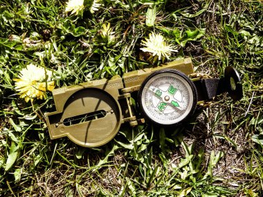 Çayırdaki pusula, seyahat ve tatil konsepti. Yaz zamanı, keşif ve yaz zamanı..