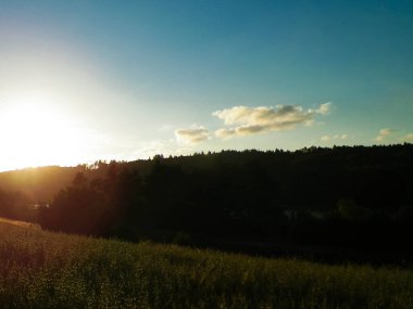 Tarlaların ve çayırların üzerinde gün batımı gökyüzü. Kashubia, Pomerania, Polonya.
