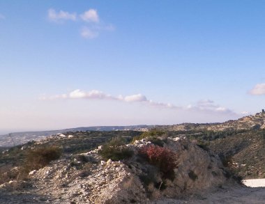 Yaz mevsiminde bir turist dağ yolunda yürüyor. Kıbrıs adasındaki Troodos Dağları. Paphos bölgesine yakın. Boşluğu mavi gökyüzünde kopyala.