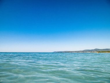 Mavi, şeffaf Tyrhenian deniz suyu mavi gökyüzü arka planında. Tatiller ve doğa konsepti. Boşluğu kopyala.