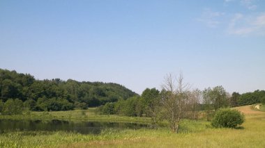 Tepeler, tarlalar ve çayırlar. Wiezyca 'nın güzel manzarası, Kashubia Bölgesi, Kuzey Polonya. Boşluğu mavi gökyüzünde kopyala.