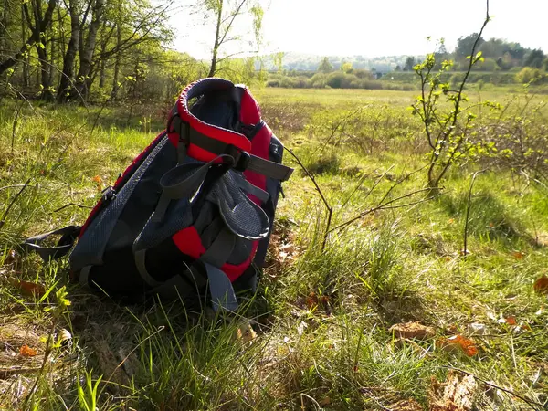 stock image Backpack on meadow. Beautiful kashubian nature. Travel to Poland concept.