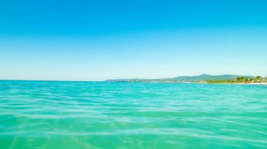 Mavi, şeffaf Tyrhenian deniz suyu mavi gökyüzü arka planında. Tatiller ve doğa konsepti. Boşluğu kopyala.