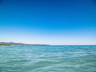 Mavi, şeffaf Tyrhenian deniz suyu mavi gökyüzü arka planında. Tatiller ve doğa konsepti. Boşluğu kopyala.