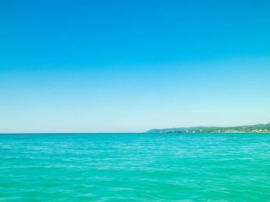 Sahil ve şeffaf, Tiren Denizi 'nin turkuaz suyu. Seyahat ve doğa kavramı. Güneşli bir yaz günü. Boşluğu kopyala.