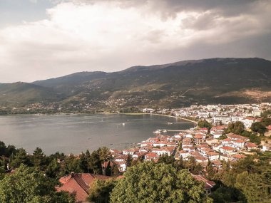 Ochrid şehrinden Ochrid Gölü kıyısında görüldü. Ochrid, Avrupa 'nın bilinen en eski gölüdür, temiz ve şeffaf sudur. Ohri ve Ohri Gölü UNESCO 'nun doğal ve kültürel mirasları. Tipik Makedon mimarisi. Seyahat ve Mimarlık dolandırıcılığı