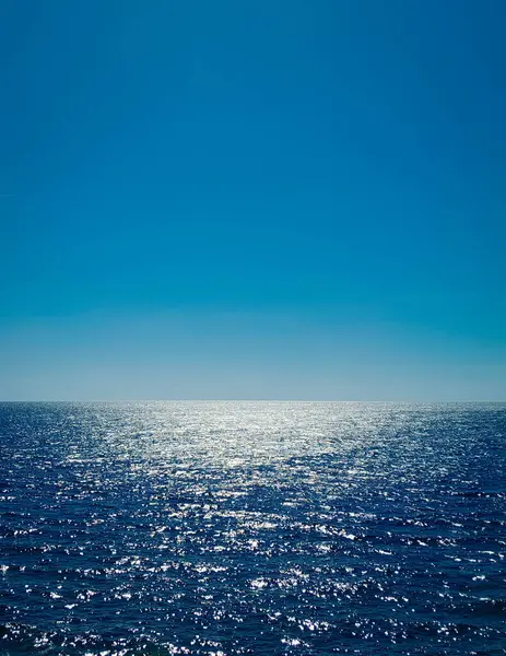 Blue sea and blue sky. Calm sea on a sunny day. Natural background, copy space.
