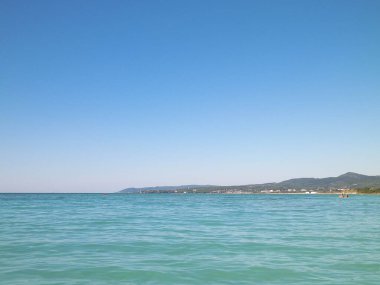 Sahil ve şeffaf, Tiren Denizi 'nin turkuaz suyu. Seyahat ve doğa kavramı. Güneşli bir yaz günü. Boşluğu kopyala.