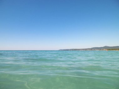 Mavi, şeffaf Tyrhenian deniz suyu mavi gökyüzü arka planında. Tatiller ve doğa konsepti. Boşluğu kopyala.