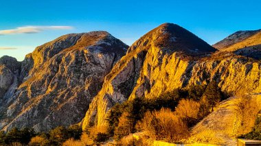 Lovcen dağı güneşli bir günde zirveye çıkar. Karadağ 'daki Boka Kotorska çevresinde Lovcen Dağları bulunuyor. Karadağ Balkanlar 'da popüler bir turizm beldesi.