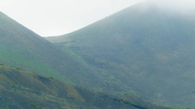 Lanzarote adasının kuzeyindeki dağ manzarası. Lanzarote adasının güzel, vahşi, tropikal doğası. Vahşi bitki örtüsü ve keşif konsepti.