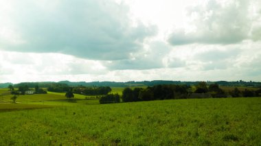 Rainy day over green fields and meadows of Kashubian Region, Poland. Copy space on cloudy sky.