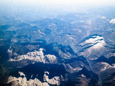 Alpler, uçağın penceresinden dağların manzarası. Toprak bükme ve doğa kavramı.