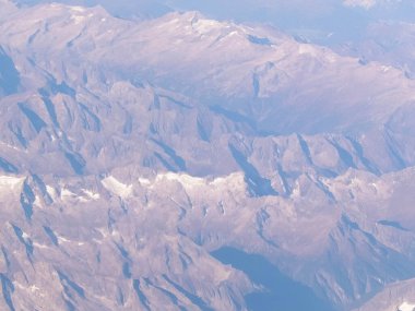 Alpler, uçağın penceresinden karlı dağ manzarası. Toprak bükme ve doğa kavramı.
