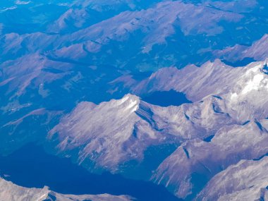 Alpler, uçağın penceresinden dağların manzarası. Toprak bükme ve doğa kavramı.