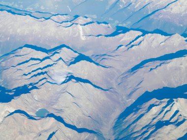 Alpler, uçağın penceresinden dağların manzarası. Toprak bükme ve doğa kavramı.