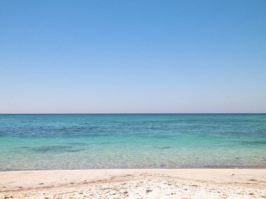 Vada 'daki kumsal, şeffaf, turkuaz su ve beyaz kum. Seyahat ve doğa kavramı.