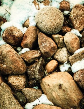 Doğanın arka planı olarak taşların üstünde kar. Kışın başlangıcı..